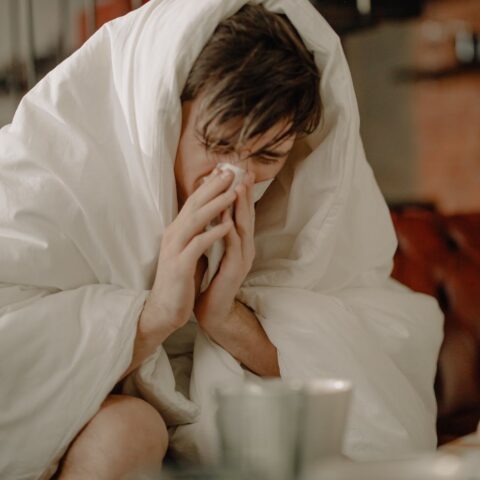 a sick man wiping his nose with tissue