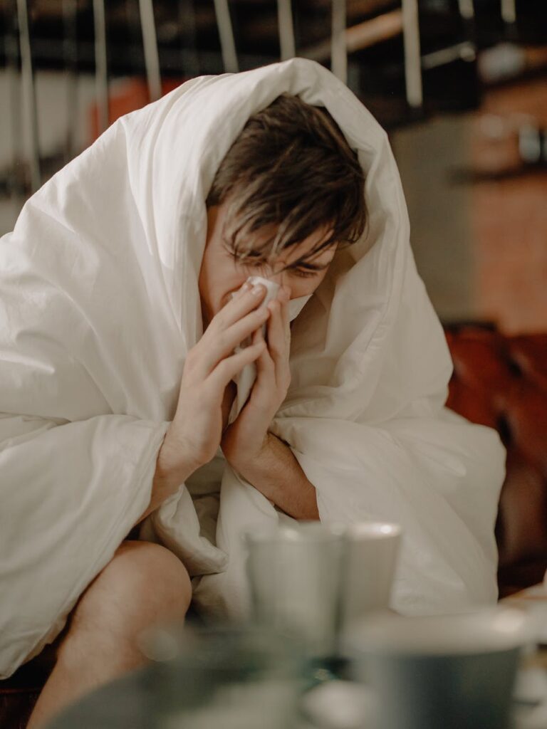 a sick man wiping his nose with tissue
